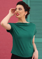 Woman with red lipstick wearing a wide neck mod green stretch rayon boat neck top