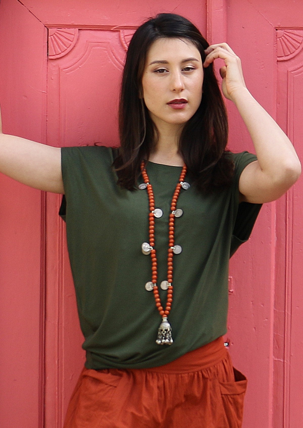 Woman wearing asymmetrical rayon top in olive green
