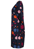 Side view of knee length cotton dress in bold spotty print on navy blue base.