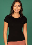 Woman with dark wearing a black stretch rayon t-shirt on a green background.